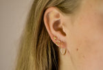 Minimalistische Niva oorstuds met drie bolletjes.