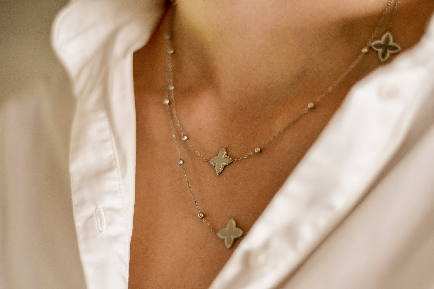 Verfijnde zilveren ketting met kleine klaverbedels.